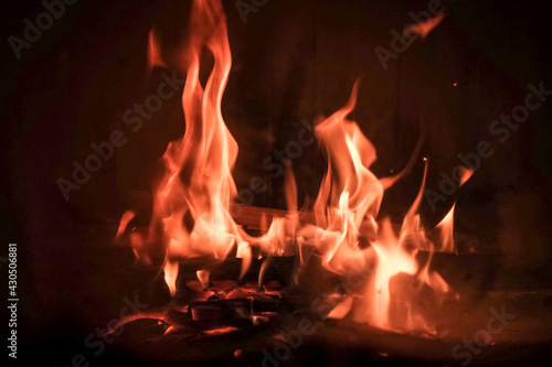 Burning fire with red, orange and yellow flames background. Arson, fire safety and danger theme. Camp fire in the night. Burning firewood in the fireplace