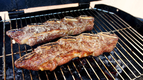 Assado de Tira or Strip roast. Traditional beef rib cut for a delicious barbecue on wooden background