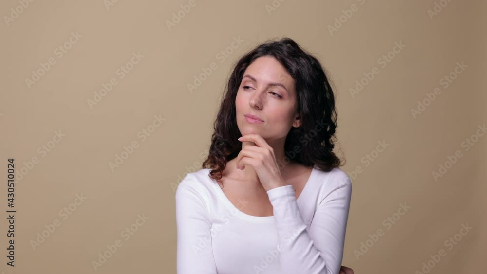 Pensive brunette female rub chin, find problem solution, ponder about plan. Smart clever woman happy coming with new idea. Portrait of thinking girl in 30s isolated over beige background, studio shot Pensive brunette female rub chin, find problem solution, ponder about plan. Smart clever woman happy coming with new idea. Portrait of thinking girl in 30s isolated over beige background, studio shot