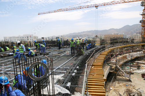 Workers working in Steel structural construction in Oman Building in Oman. Oman city