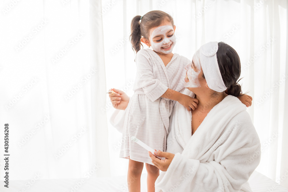 Fototapeta premium dia de Spa mama e hija con mascarilla blanca y fondo blanco