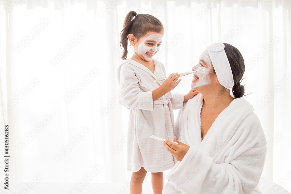 Obraz premium dia de Spa mama e hija con mascarilla blanca y fondo blanco