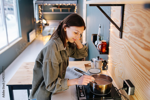 Patient woman cooking on a high kitchen table  stirring soup on a stove