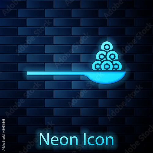 Glowing neon Caviar on a spoon icon isolated on brick wall background. Vector.
