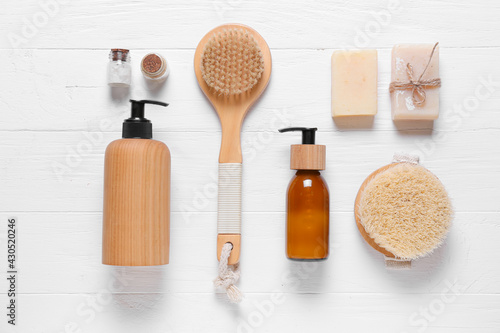 Composition with massage brushes and bath supplies on light wooden background