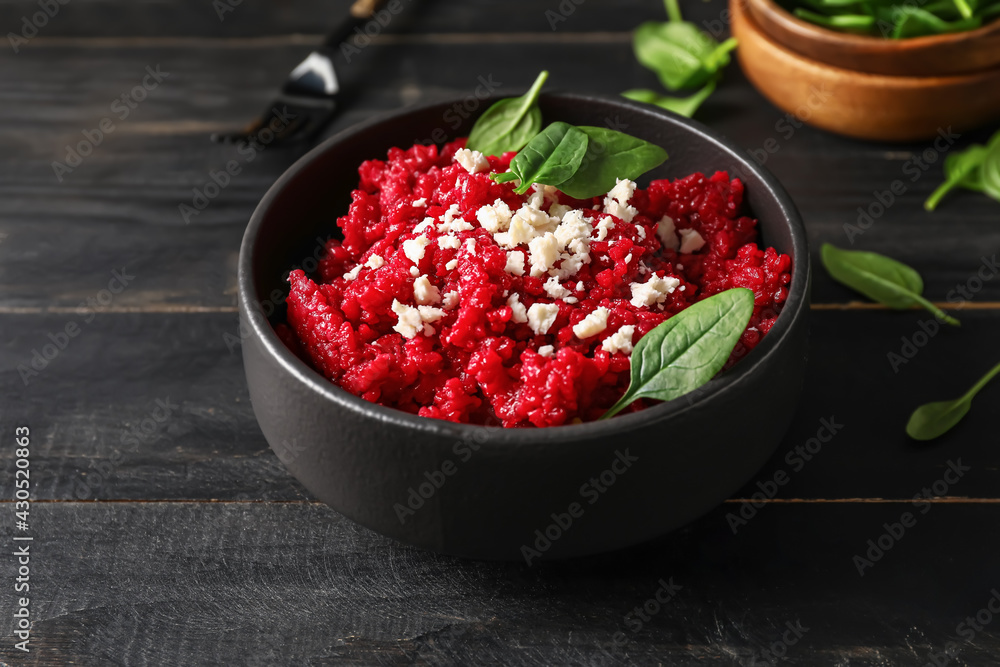 Bowl with tasty beet risotto on dark wooden background Bowl with tasty beet risotto on dark wooden background