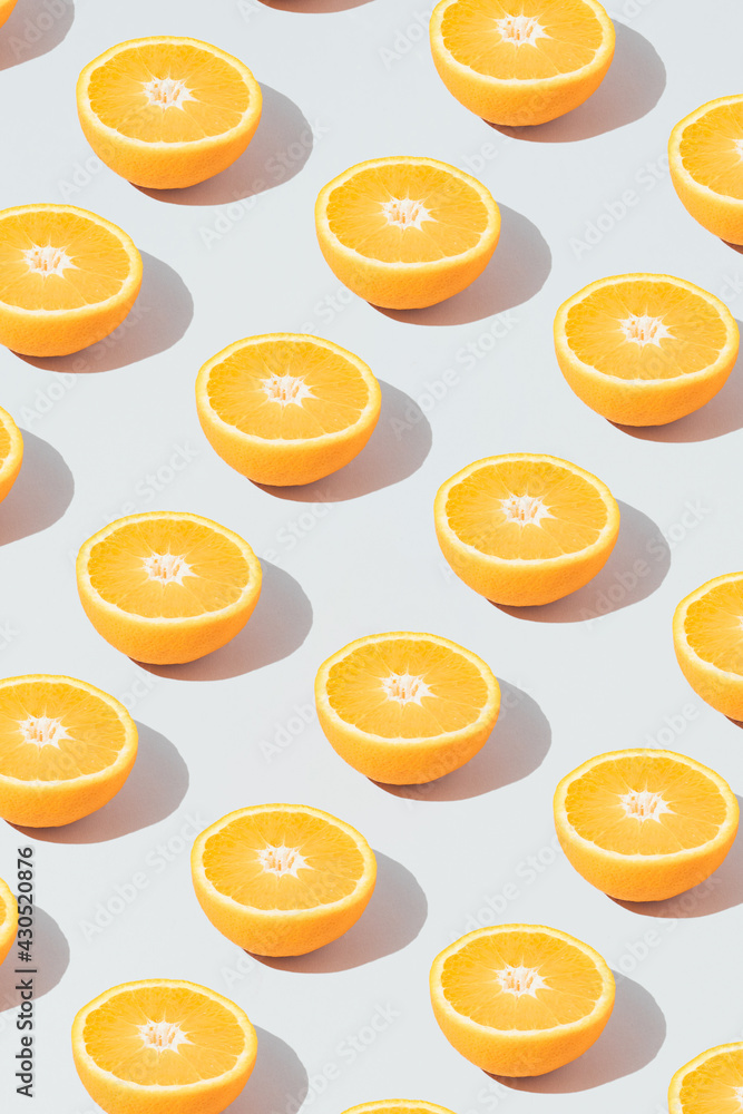 Pattern made with fresh sliced orange on the gray background. Minimal fruit or food concept. Flat lay, top view. Pattern made with fresh sliced orange on the gray background. Minimal fruit or food concept. Flat lay, top view.