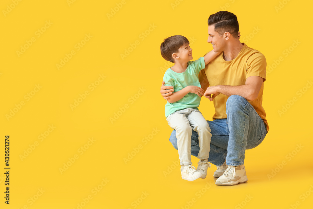 Happy father and his little son on color background Happy father and his little son on color background