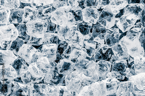 Pieces of shiny crushed ice cubes pattern on black background.