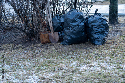 Black plastic garbage bags in the park, spring cleaning.