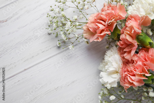 Fresh carnation flowers on wooden background