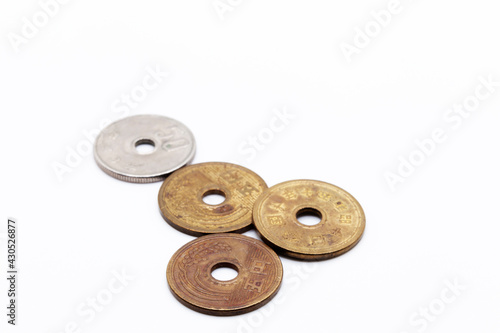 four Chinese coins with holes in the middle on a white background