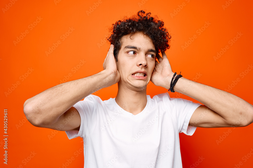 guy in a white t-shirt gesturing with his hand on an orange background guy in a white t-shirt gesturing with his hand on an orange background