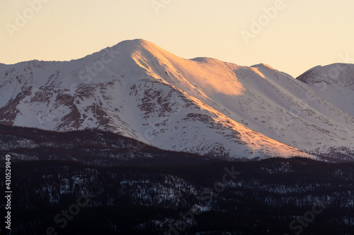 Beautiful scenic view of northern Canada during spring time, April of a snow capped huge mountain peak. Wilderness territory in Yukon, Canada. 