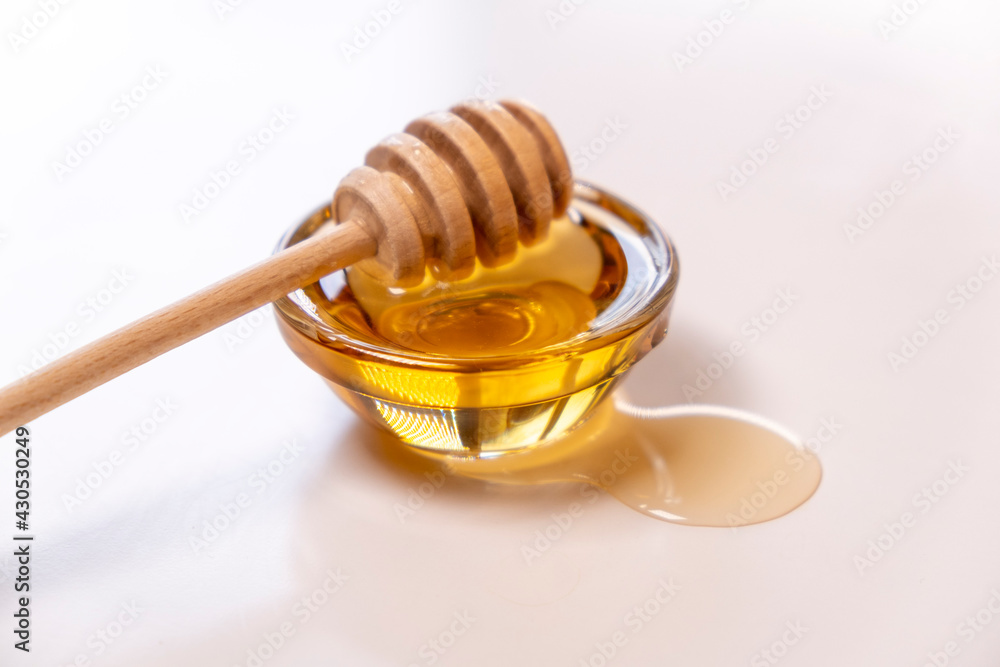 Liquid Organic Honey on a Special Honey Spoon in Bowl Close Up Shot. Liquid Organic Honey on a Special Honey Spoon in Bowl Close Up Shot.