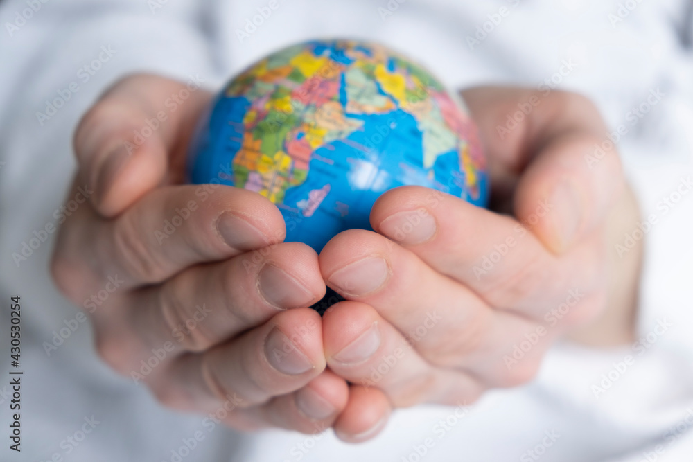 hands holding the ground. Earth globe in hands on a white background close up hands holding the ground. Earth globe in hands on a white background close up