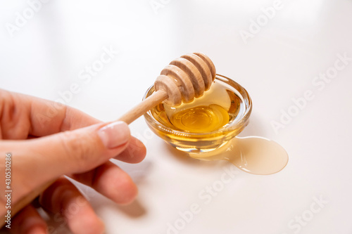 Liquid Organic Honey on a Special Honey Spoon in  Bowl Close Up Shot. © Pavlo
