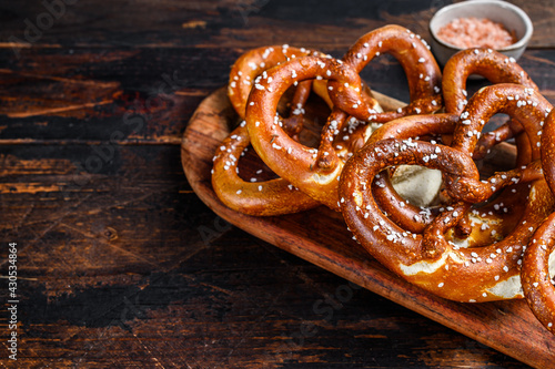 Homemade Soft Pretzels with Salt on a wooden board. Dark wooden background. Top view. Copy space