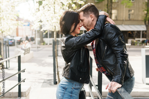 Beautiful couple in love wearing leather jackets during a date on a city street