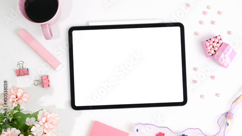 Mockup tablet and female accessories surrounded with coffee on white desk.