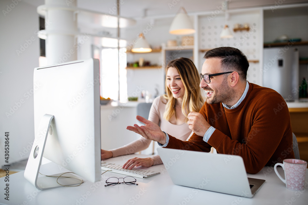 Happy successful business partners working at meeting in office Happy successful business partners working at meeting in office
