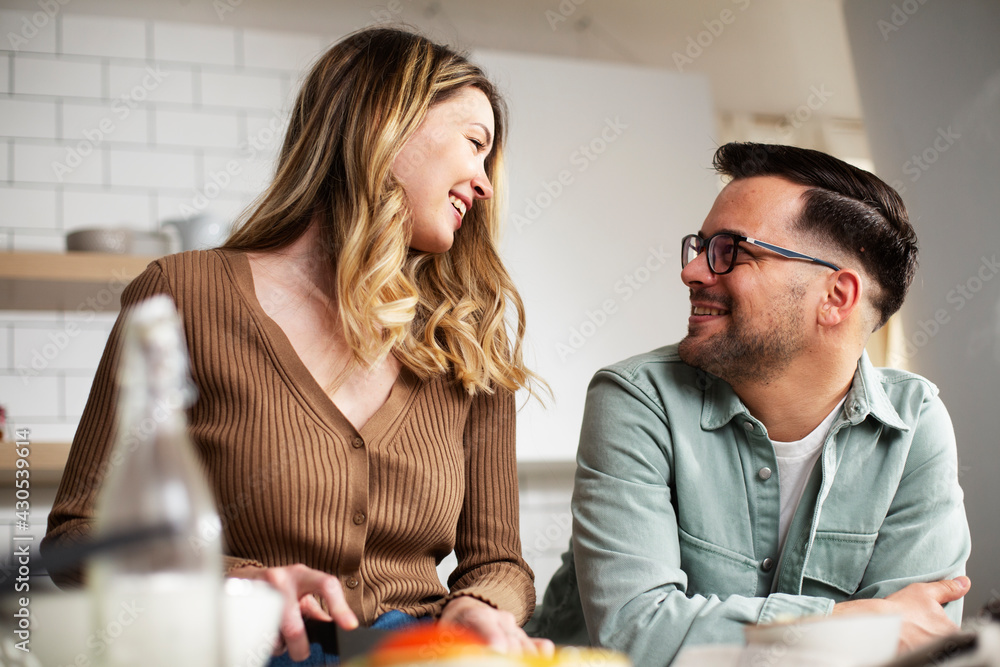 Happy smiling couple cooking together. Boyfriend and girlfriend preparing pasta at home Happy smiling couple cooking together. Boyfriend and girlfriend preparing pasta at home