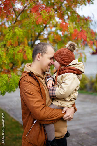 portrait of happy father and hugging his little daughter in autumn park
