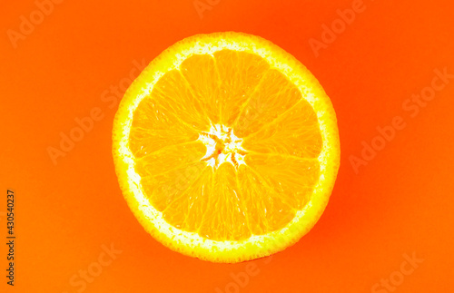 Close up photo of orange texture on the orange background. Fruit cut in half, inside, macro view. Minimalism, original and creative image. Beautiful natural wallpaper.