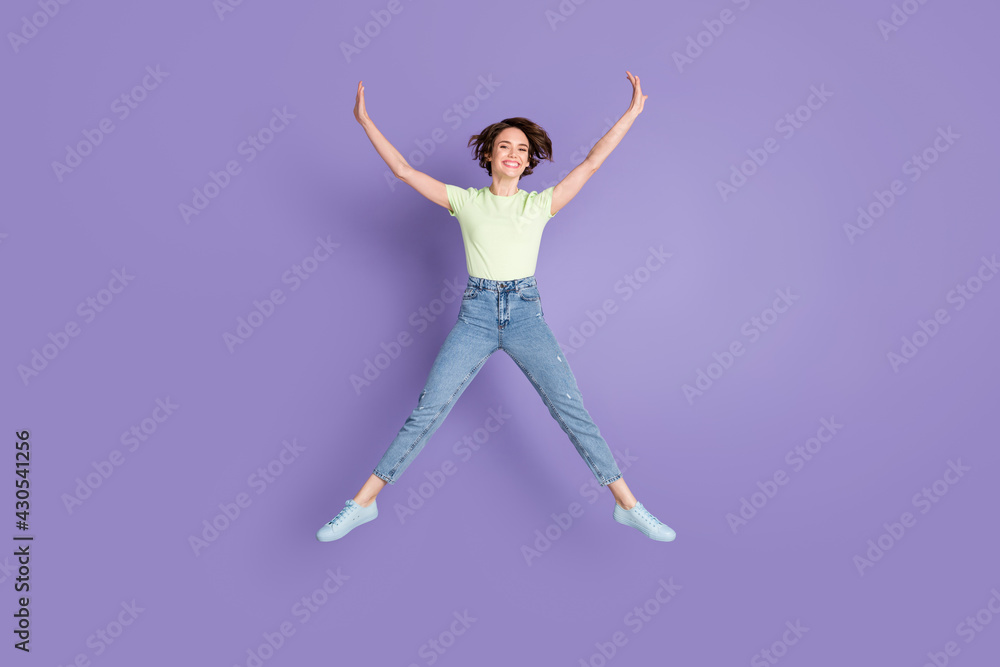 Full length body size view of lovely cheerful skinny girl jumping having fun isolated over violet color background