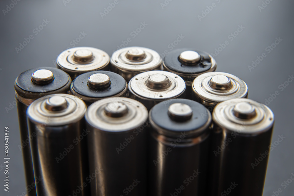 Batteries arranged side by side, on a dark surface. Batteries, energy and respect for the environment. Alkaline or rechargeable batteries. Batteries arranged side by side, on a dark surface. Batteries, energy and respect for the environment. Alkaline or rechargeable batteries.