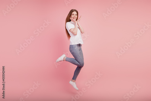 Fototapeta Naklejka Na Ścianę i Meble -  Photo of adorable funny girl jump high hands face up on pink background
