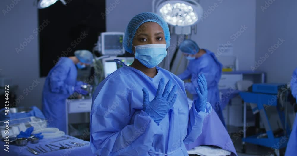 African american female surgeon wearing face mask and protective clothing in operating theatre African american female surgeon wearing face mask and protective clothing in operating theatre