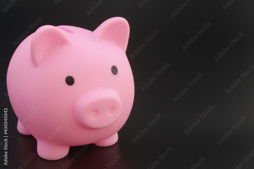 Piggy bank on black table, copyspace for text.