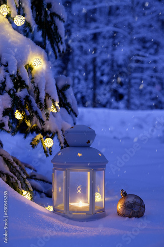 Christmas tree, garland and lamp in the snow-covered forest. Snow-covered forest for Christmas