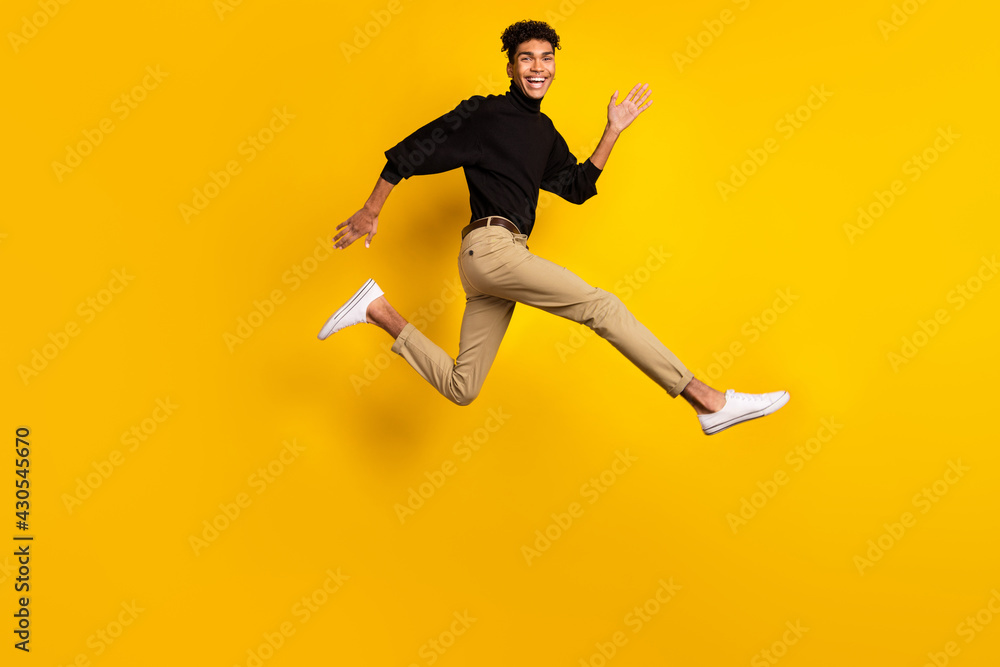Obraz premium Photo of pretty charming dark skin man wear black sweater eyewear running fast jumping isolated yellow color background