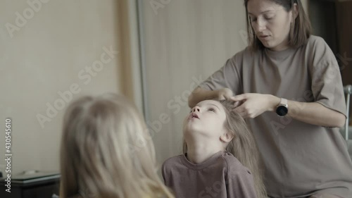Mom braids daughters at home
