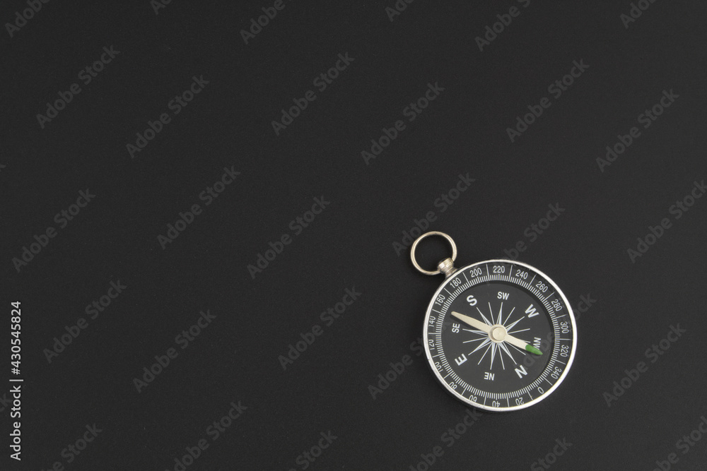 Compass on black table with room for text