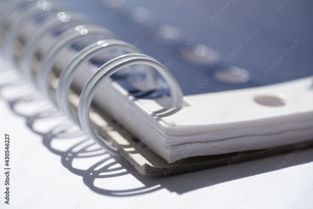 Close-up of a part of a closed ring binder with drop shadow with white space on the left. Narrow depth of field Close-up of a part of a closed ring binder with drop shadow with white space on the left. Narrow depth of field