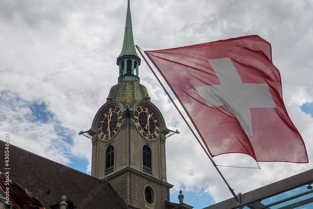 View of Holy Spirit Church (Heiliggeistkirche) and Switzerland flag in Bern Switzerland