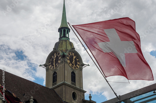 View of Holy Spirit Church (Heiliggeistkirche) and Switzerland flag in Bern Switzerland photo