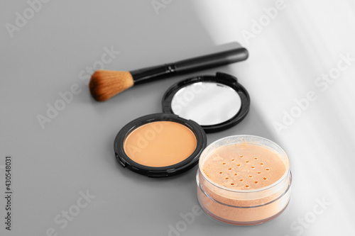 Open box with make up face powder on gray background