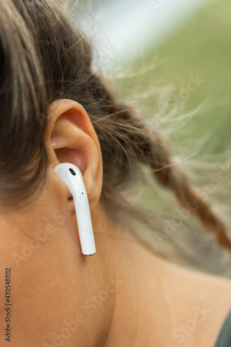 Female ear with wireless earbud