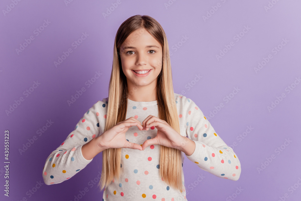 Young kid girl show on chest fingers heart love sign over violet background Young kid girl show on chest fingers heart love sign over violet background