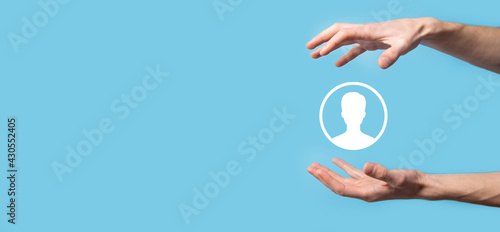 Hand holds user person icon interface on blue background.User symbol for your web site design, logo, app, UI.Banner © Ivan