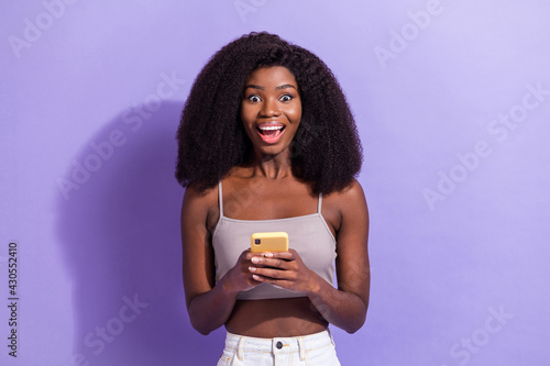Portrait of attractive cheerful girl using gadget browsing media comment like having fun isolated over violet purple color background
