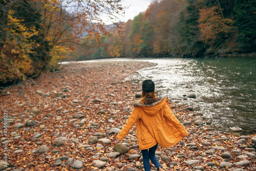 woman walking in the forest along the river autumn travel woman walking in the forest along the river autumn travel