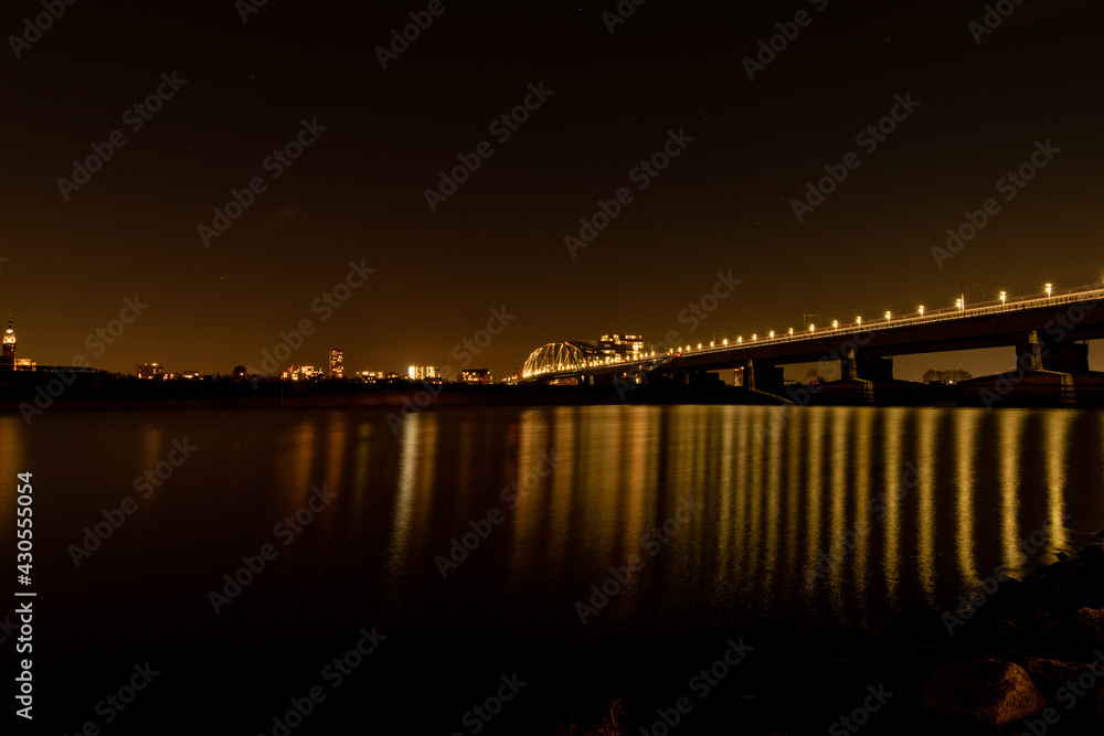 Night wide city view of Nijmegen. Bridge at night, reflection in the water