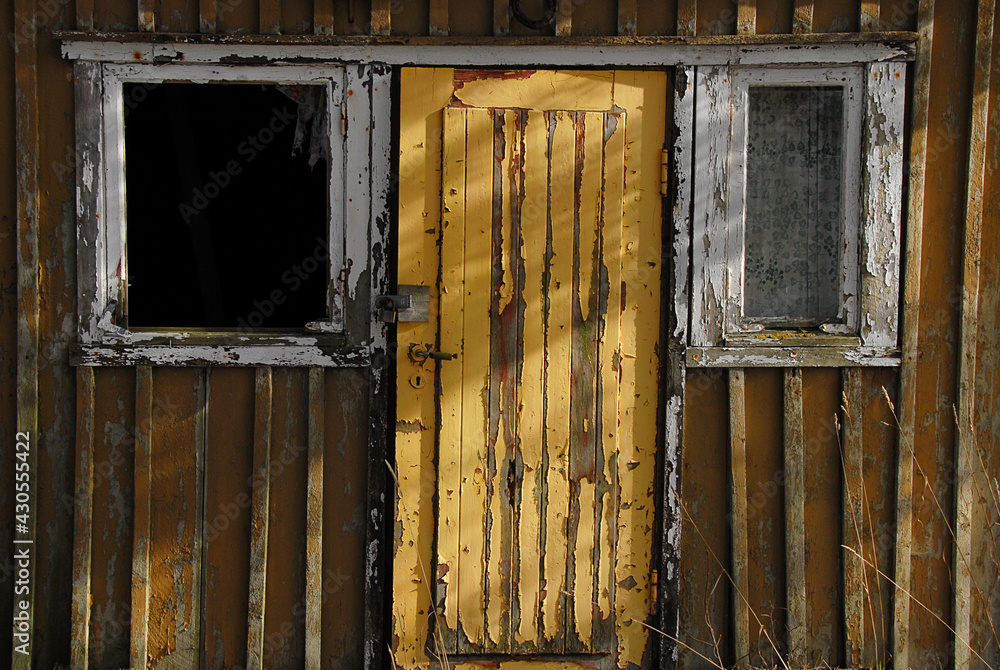 old wooden facade with door between two windows