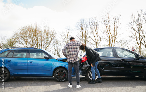 Fotografi Young Male And Female Drivers Getting Out Of Cars And Inspecting Damage After Ro