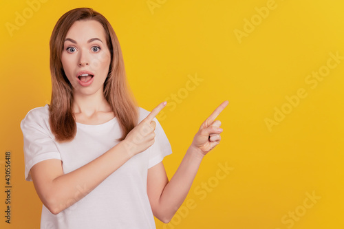 Photo of happy elegant woman indicate empty space open mouth on yellow background